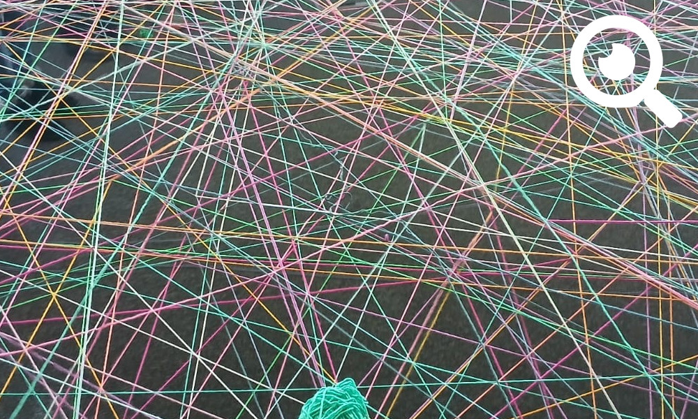 Berater*innen machen aus buntes Fäden gemeinsam ein Netz